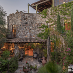 Facade of a stone house with extensive garden